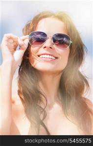 picture of beautiful woman in sunglasses on a beach