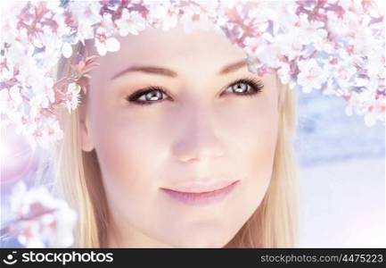 Picture of beautiful woman outdoors in spring time, closeup portrait of cute blonde female wearing pink floral wreath, cherry blossom, spring flowers blooming, natural makeup, harmony concept