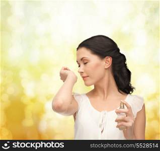 picture of beautiful woman smelling pefrume on her hand