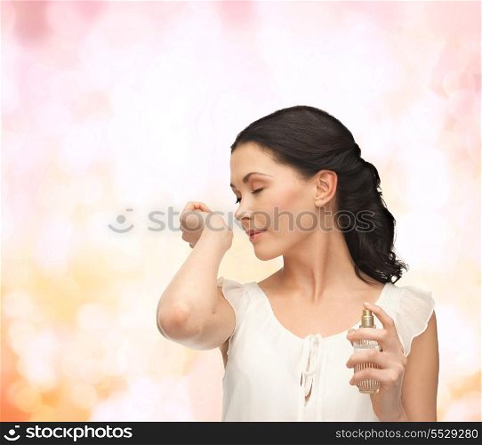 picture of beautiful woman smelling pefrume on her hand