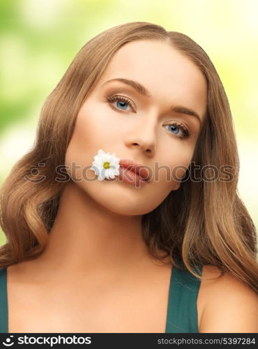 picture of beautiful woman with camomile in mouth