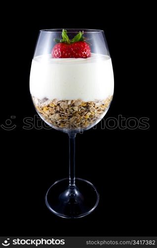 Picture of breakfast, musli and yogurt in a wine glass. With a strawberry on the top