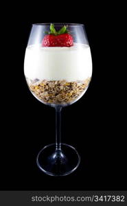 Picture of breakfast, musli and yogurt in a wine glass. With a strawberry on the top