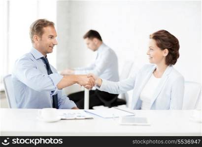 picture of businessman and businesswoman shaking hands in office