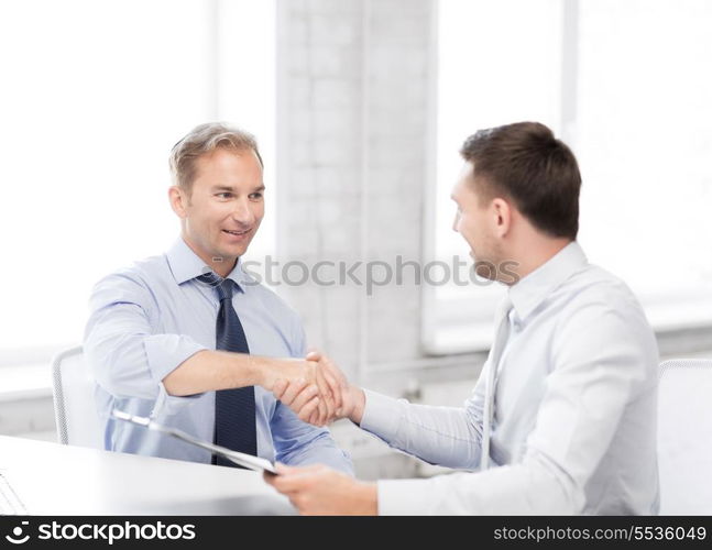 picture of businessmen shaking hands in office