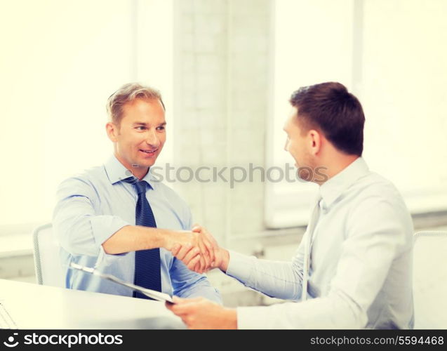 picture of businessmen shaking hands in office