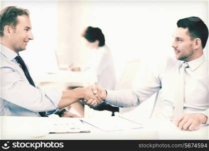 picture of businessmen shaking hands in office