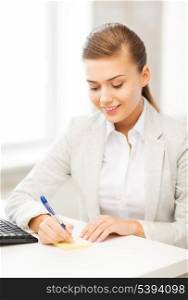 picture of businesswoman writing on sticky note