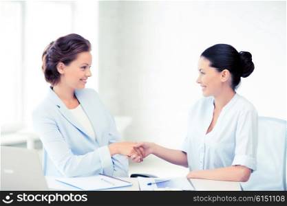 picture of businesswomen shaking hands in office. businesswomen shaking hands in office