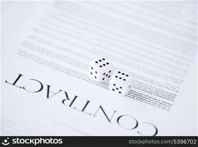 picture of contract paper with gambling dices