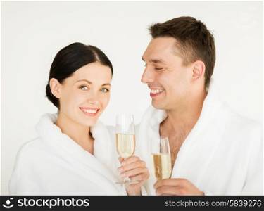 picture of couple in spa salon in white bathrobes with champagne. couple in spa