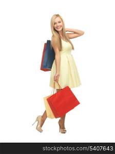 picture of elegant woman with shopping bags in dress and high heels.