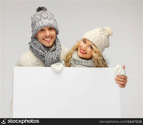 picture of family couple in a winter clothes holding blank board