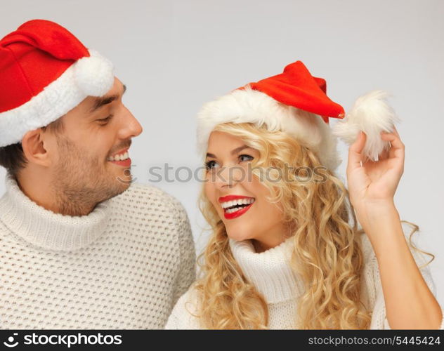 picture of family couple in sweaters and santa&#39;s hats