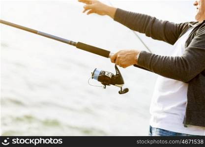 Picture of fisherman&amp;#39;s hands holding rod and fishing