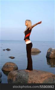 picture of fit girl meditating at the seashore