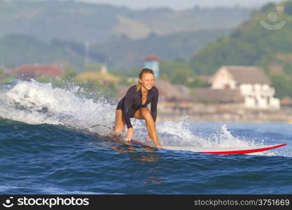 picture of girl surfing a wave in Indonesia.Lombok island.