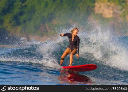 picture of girl surfing a wave in Indonesia.Lombok island.