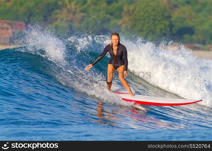 picture of girl surfing a wave in Indonesia.Lombok island.