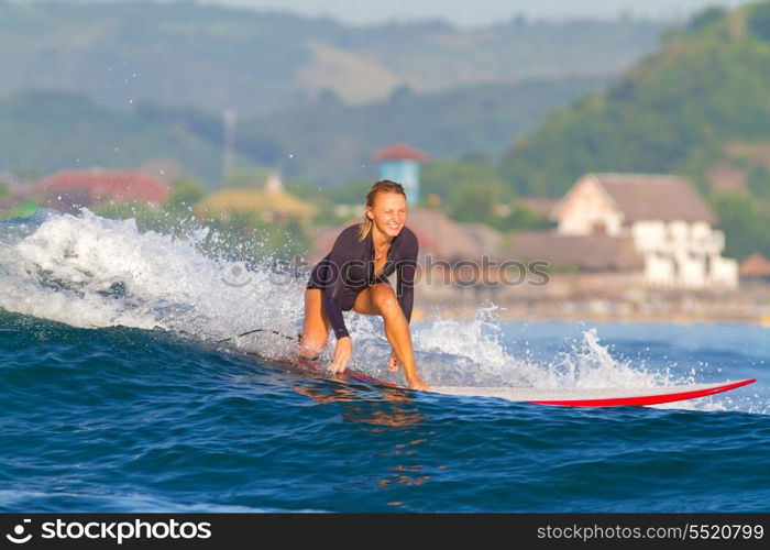 picture of girl surfing a wave in Indonesia.Lombok island.