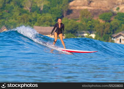 picture of girl surfing a wave in Indonesia.Lombok island.