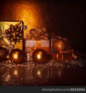 Picture of golden gift boxes on dark grunge background, variety of presents decorated with Christmas tree toys, studio shot, happy New Year greeting card, shopping concept, x-mas surprise