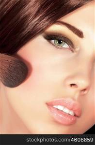 Picture of gorgeous woman with brown silky hair doing evening makeover, sexy look, smoky eyes, fashionable makeup, stylish visage, professional cosmetics brush and tassel, luxury beauty salon