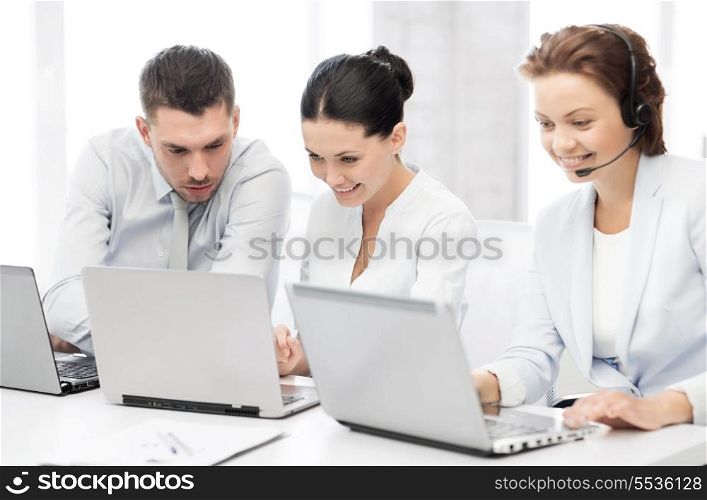 picture of group of people working with laptops in office