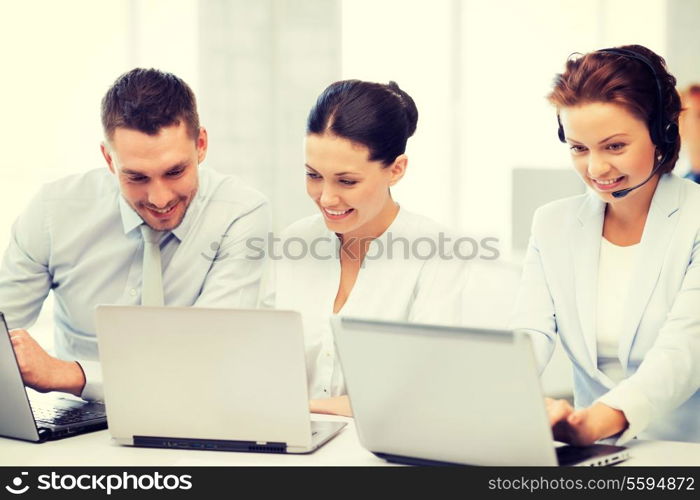 picture of group of people working with laptops in office