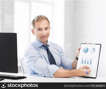 picture of handsome businessman showing graphs and charts