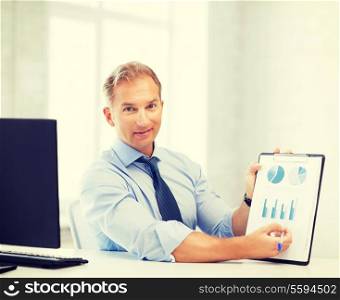 picture of handsome businessman showing graphs and charts