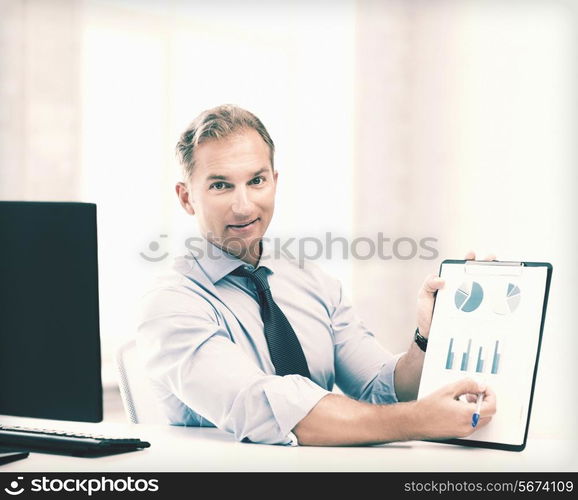 picture of handsome businessman showing graphs and charts