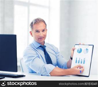 picture of handsome businessman showing graphs and charts. businessman showing graphs and charts