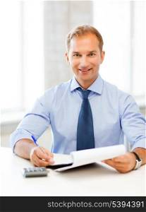 picture of handsome businessman with notebook and calculator