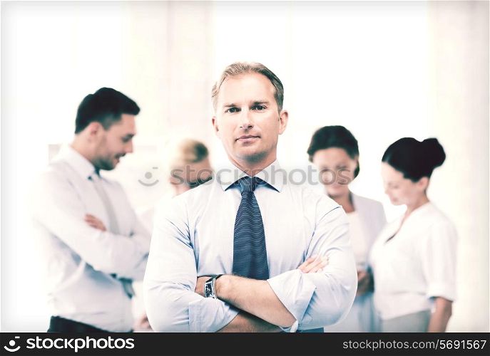 picture of handsome businessman with team in office
