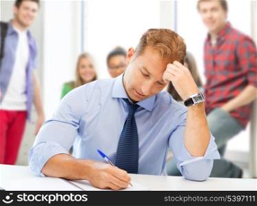 picture of handsome teacher writing in notebook