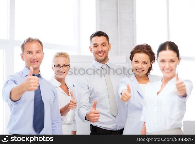 picture of happy business team showing thumbs up in office