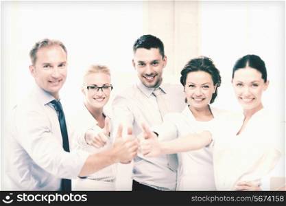 picture of happy business team showing thumbs up in office