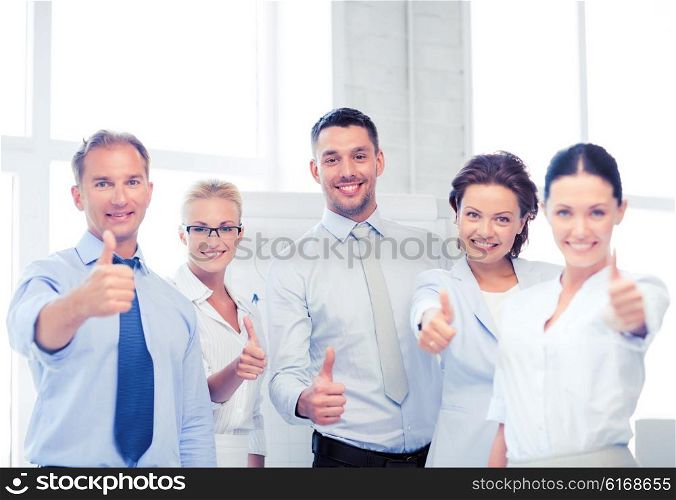 picture of happy business team showing thumbs up in office. business team showing thumbs up in office