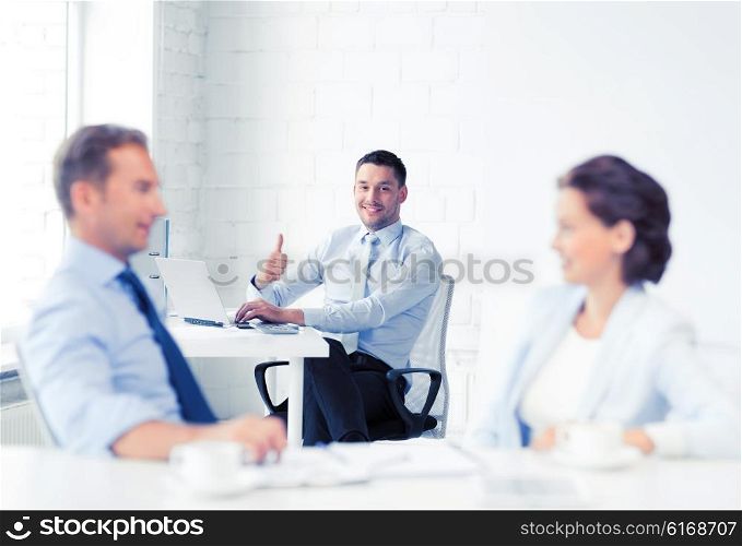 picture of happy businessman showing thumbs up in office. happy businessman showing thumbs up in office