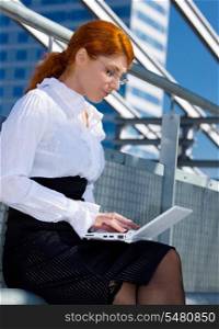 picture of happy businesswoman with laptop in the city