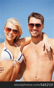 picture of happy couple in sunglasses on the beach. (focus on man)