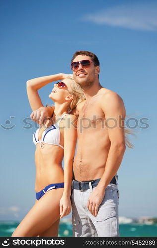 picture of happy couple in sunglasses on the beach (focus on man).