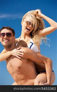 picture of happy couple in sunglasses on the beach (focus on woman)