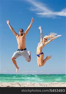 picture of happy couple jumping on the beach (focus on man)