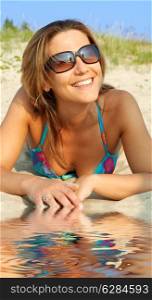 picture of happy girl tanning on sand