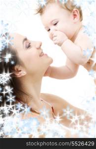 picture of happy mother with baby and snowflakes (focus on baby)