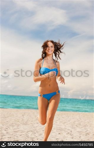 picture of happy smiling woman jogging on the beach.