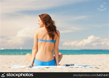 picture of happy smiling woman sitting on a towel.