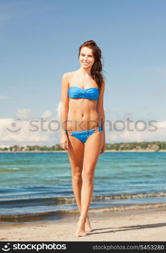 picture of happy smiling woman walking on the beach.